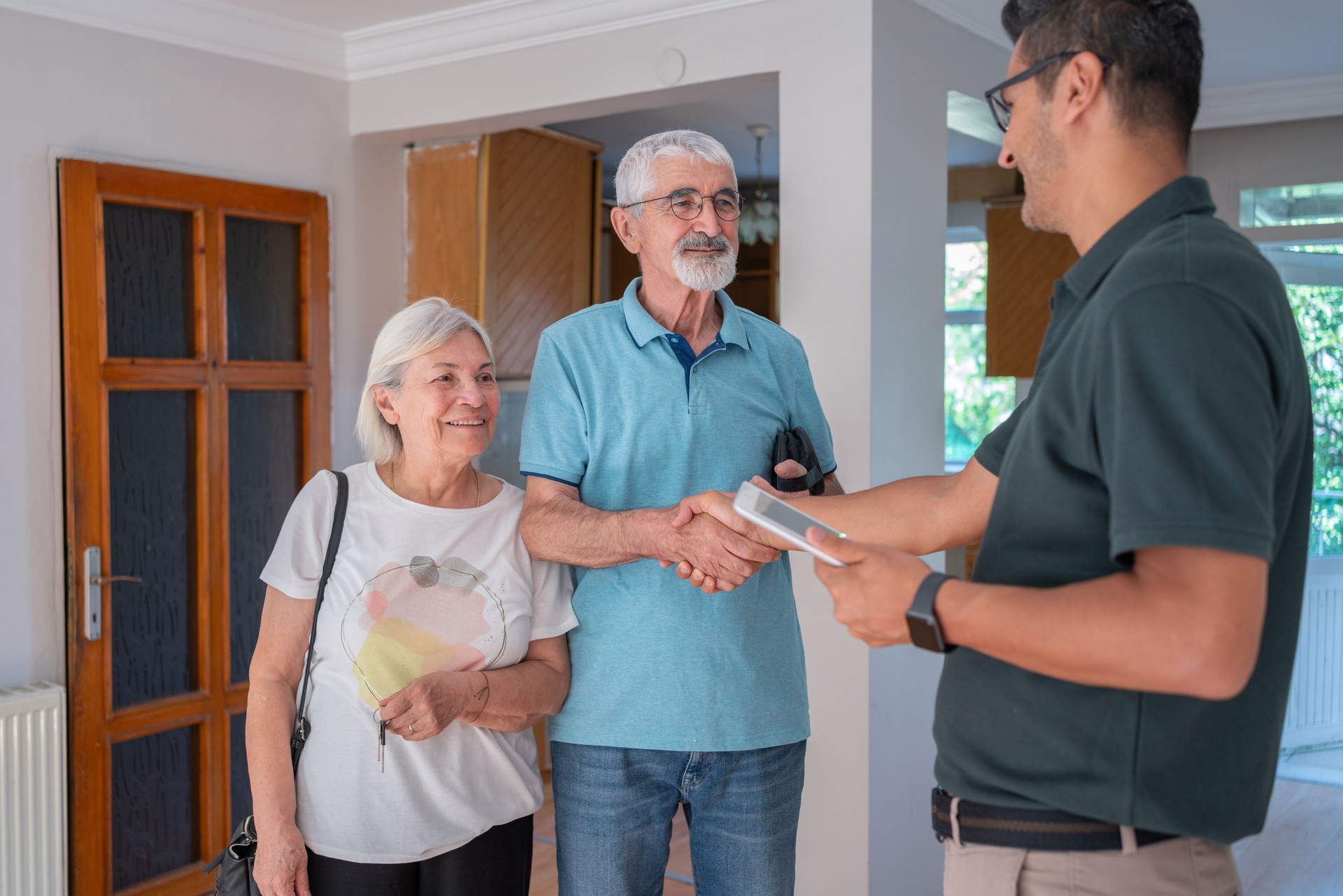 Senior Couple Handshake With Stairlift Agent At Home